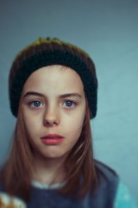 Close-up portrait of girl against wall