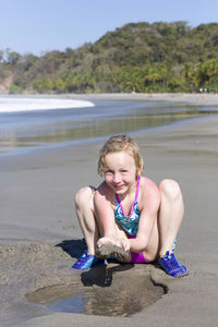 Portrait of smiling girl playing at beach