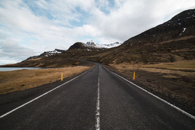 Road leading towards mountains against sky