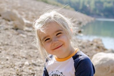 A joyful scene cheerful girl relaxing by the lake on a sunny day with a rocky backdrop