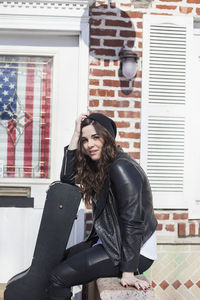 Young woman carrying a guitar case through the snow