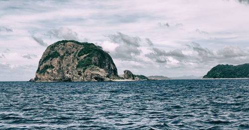 Scenic view of rock formation in sea against sky