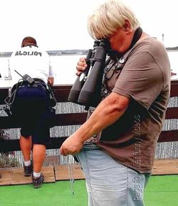 Rear view of man photographing with daughter standing outdoors