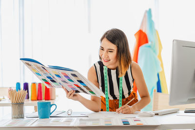 Woman looking at camera while sitting on table