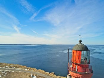 Lighthouse by sea against sky