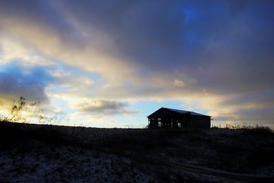 Silhouette house against sky during sunset