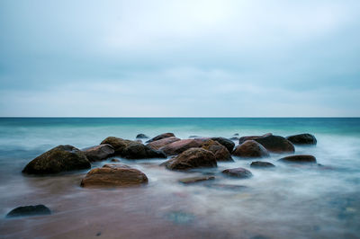 Rocks in sea against sky