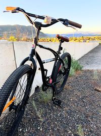 Bicycle parked on road against sky