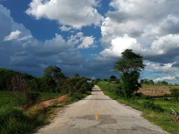 Road amidst trees against sky