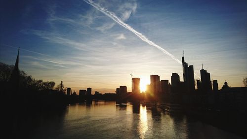 Scenic view of vapor trails in sky at sunset