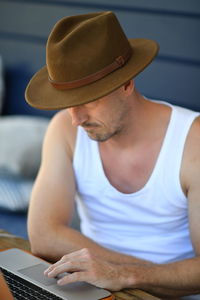 Man using laptop while sitting by table