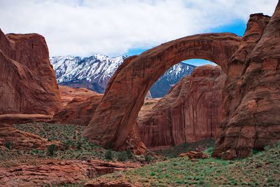 View of rock formation against cloudy sky rock arch 