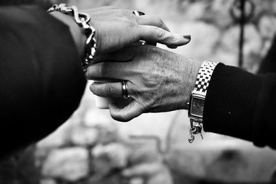 Midsection of man holding hands against blurred background