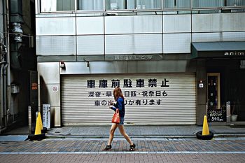 WOMAN STANDING IN FRONT OF BUILDING