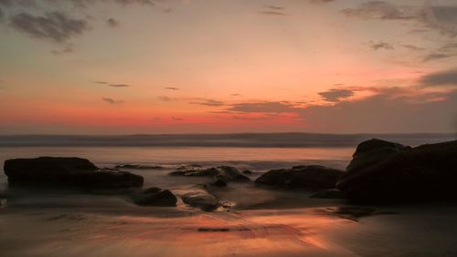 Scenic view of sea against romantic sky at sunset