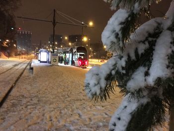 Snow covered car on street at night