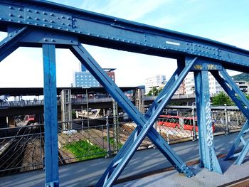 Bridge over river in city against sky