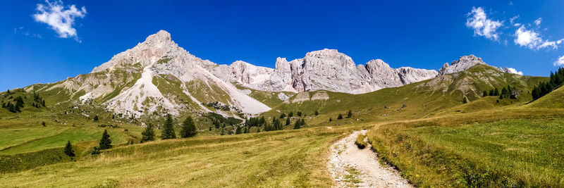 Panoramic view of snowcapped mountains against blue sky