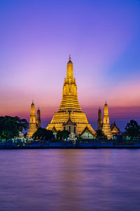 Illuminated temple building against sky at dusk