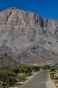 Road by mountain against sky