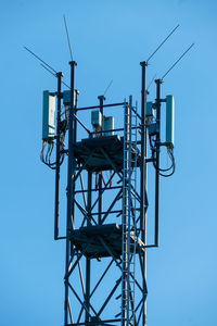 Low angle view of electricity pylon against clear sky