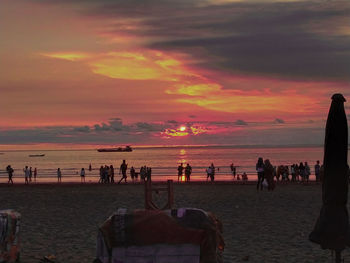 Group of people on beach during sunset