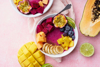 Top view smoothie bowl with dragon fruit, mango and papaya