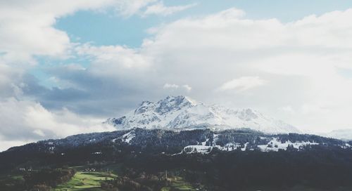 Scenic view of snowcapped mountains against cloudy sky