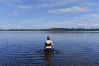 Rear view of man on lake against sky