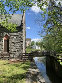 Arch bridge over canal by building against sky