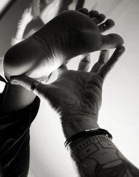 Close-up of man holding hands over white background