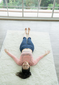 High angle view of woman lying down on window