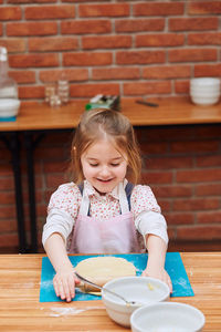 Close-up of cute girl eating food at table at home