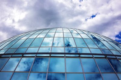 Low angle view of modern building against cloudy sky