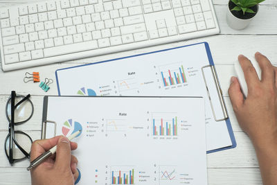 Midsection of man using mobile phone on table