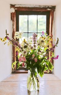 Flowers in vase against window