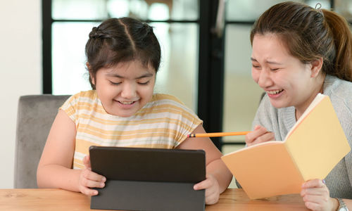 Young woman using laptop while sitting on sofa at home