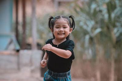 Portrait of smiling girl standing outdoors