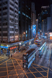 Vehicles on road in illuminated city at night