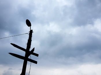 Low angle view of silhouette pole against cloudy sky