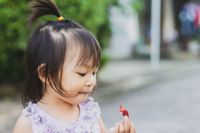 Close-up portrait of cute girl with arms raised