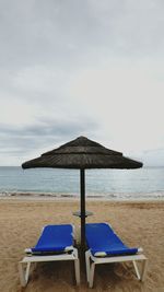 Chair on beach against sky