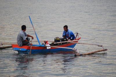 Men sitting on boat in sea