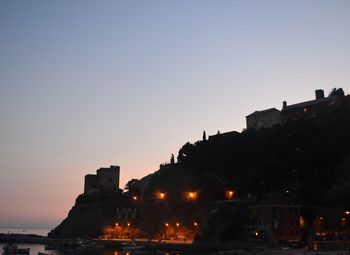 Illuminated buildings against sky during sunset