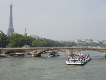 Boats in river with city in background
