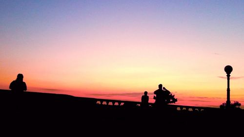 Silhouette men against sky during sunset