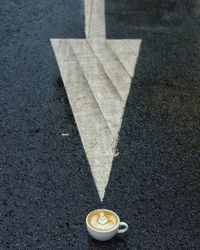 Close-up of coffee cup on road