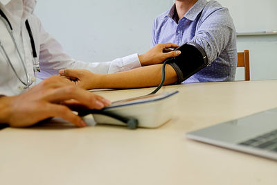 Surface level of doctor examining blood pressure of patient