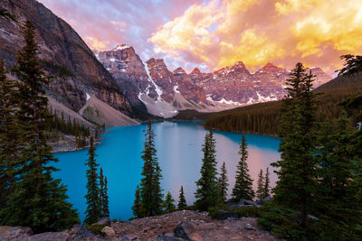 Scenic view of lake by mountains against sky during sunset