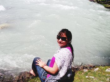 High angle view of woman sitting on sea shore